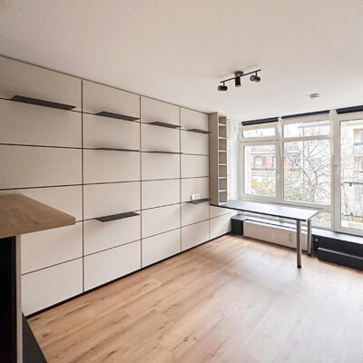 1-Zimmer-Apartment im München, City, Museumviertel: Leben, Wohnraum mit großer Fensterfront. Verkauft durch Quartiere Ulrike Küpper.